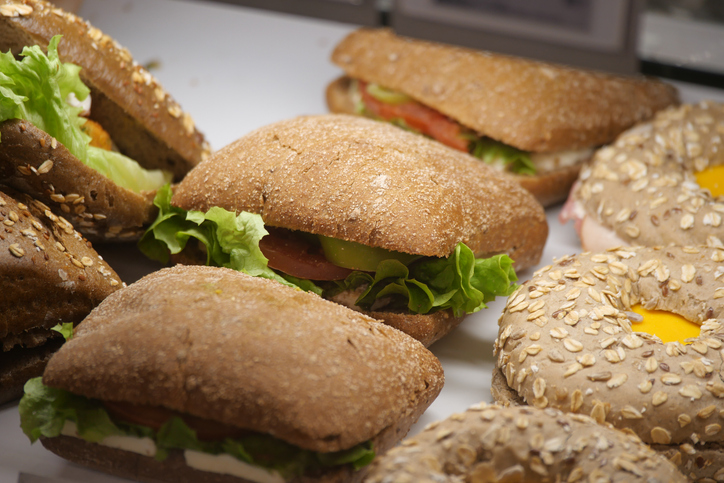 Fresh sandwiches and rolls displayed in a bakery showcase
